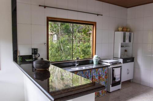 cocina con fregadero y ventana en Linda Casa em Buenos Aires Guarapari, en Guarapari