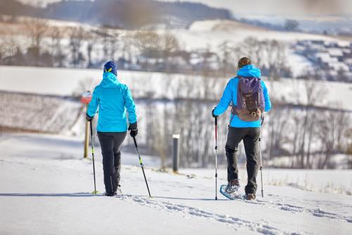 two people are cross country skiing in the snow at Parkhotel Bad Griesbach in Bad Griesbach