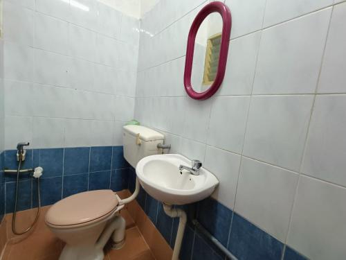 a bathroom with a toilet and a sink at Kota Lodge in Melaka