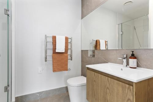 een badkamer met een witte wastafel en een toilet bij Enfield Sky - Brand New Luxury Penthouse in Auckland