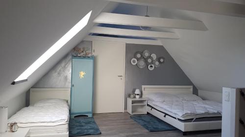 a attic bedroom with two beds and a staircase at Gästehaus Storchenhof in Niepars