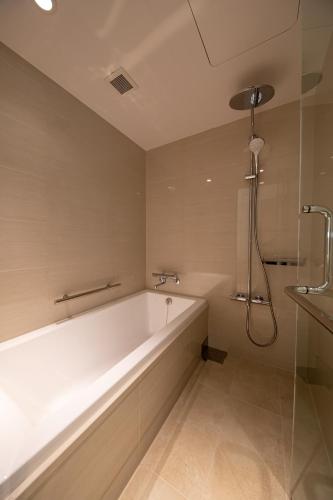 a bathroom with a bath tub and a shower at THE GENERAL KYOTO Shijou Shinmachi in Kyoto