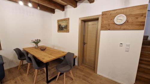 a dining room with a table and a clock on the wall at Mytho 1 in Mýto pod Ďumbierom