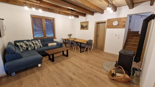 a living room with a blue couch and a table at Mytho 1 in Mýto pod Ďumbierom