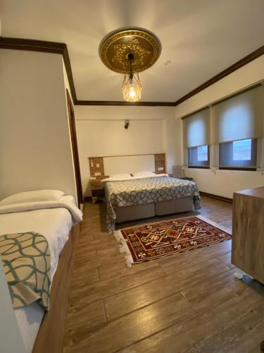 a bedroom with two beds and a chandelier at Ziyagil Konağı in Amasya