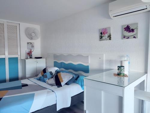 a bedroom with a bed and a table in it at Studio entre ciel et mer sans coupure d'eau in Le Gosier