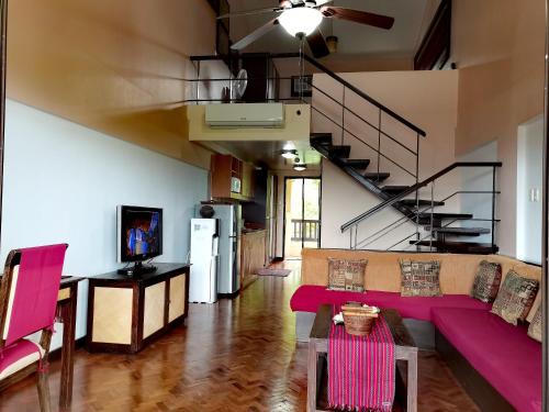 a living room with a purple couch and a staircase at Unit 306 Alta Vista de Boracay by David in Boracay