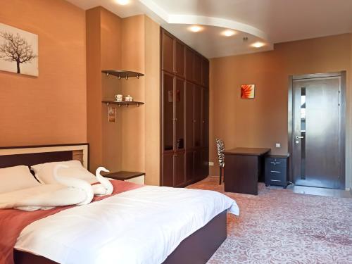 een slaapkamer met een groot bed en een bureau bij A paradise for large groups in Tbilisi City