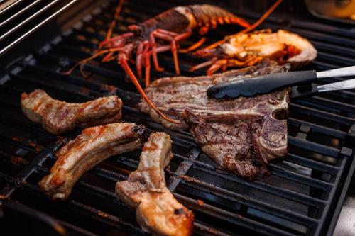 a bunch of meat and seafood on a grill at Luxury Trailers 離宮 伊勢 in Sōchi