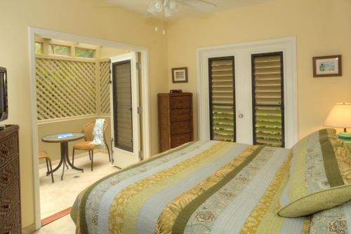 a bedroom with a bed and a table and a chair at Gallows Point Resort in Saint John