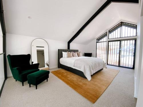 a bedroom with a large bed and a green chair at Le Soleil new villa, golf & heated pool in Dunsborough