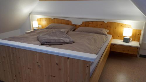 a bedroom with a large bed with a wooden headboard at Biohof Kroisleitner in Sankt Jakob im Walde