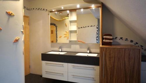 a bathroom with two sinks and a large mirror at Biohof Kroisleitner in Sankt Jakob im Walde