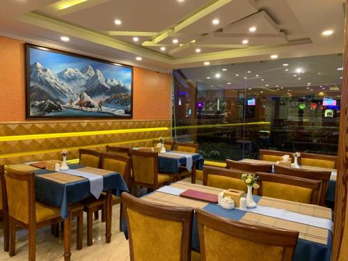 a restaurant with tables and chairs and a painting on the wall at Grand Yak Boutique Hotel in Kathmandu