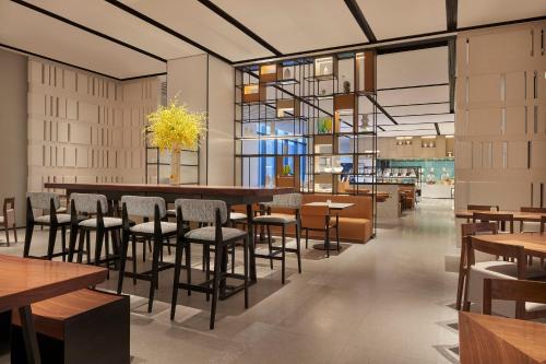 Un restaurante con mesas y sillas y una lámpara de araña. en Hyatt Place Hangzhou International Airport, en Hangzhou