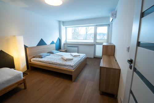 シュクラルスカ・ポレンバにあるApartament KRIS 412の小さなベッドルーム(ベッド1台、窓付)