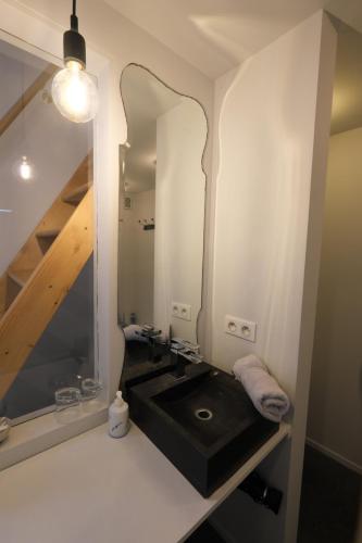 a bathroom with a black sink and a mirror at Maison d'Hôtes Cerf'titude in Érezée