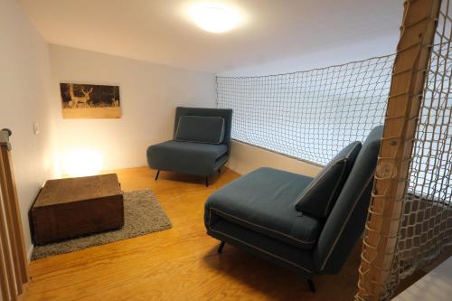 a living room with two chairs and a ottoman at Maison d'Hôtes Cerf'titude in Érezée