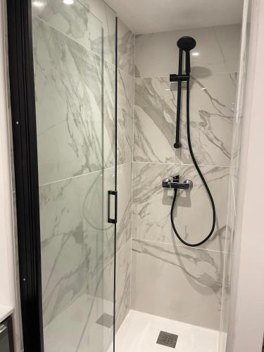 une salle de bain avec une douche avec une porte vitrée dans l'établissement Appartement 2 chambres en plein centre ville, à Chalon-sur-Saône