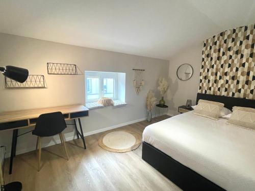 a bedroom with a bed and a desk and a window at Appartement 2 chambres en plein centre ville in Chalon-sur-Saône