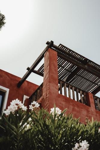 a red brick building with windows and flowers in the foreground at Candia Park Village in Agios Nikolaos