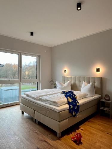 a bedroom with a large bed and a large window at NEU! Feriendomizil TraumZeit 1 mit Sauna & Garten in Göhren-Lebbin