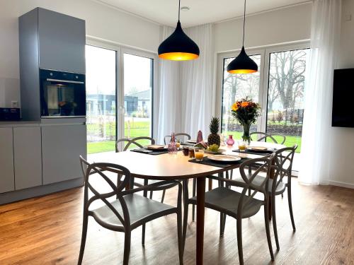 una cucina e una sala da pranzo con tavolo e sedie di NEU! Feriendomizil TraumZeit 1 mit Sauna & Garten a Göhren-Lebbin