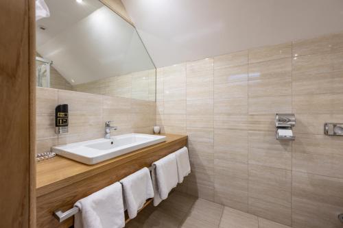 a bathroom with a sink and white towels at Villa Ambach in Oetz