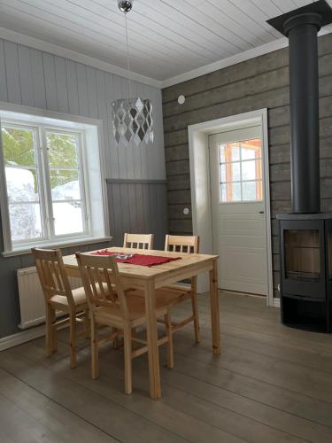 a dining room with a table and chairs and a stove at Helsingegården in Järvsö