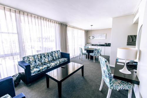 a living room with a couch and a table at Lagoon Beach Hotel & Spa in Cape Town