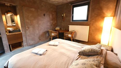 a bedroom with a large bed with two towels on it at Maison d'Hôtes Cerf'titude in Érezée