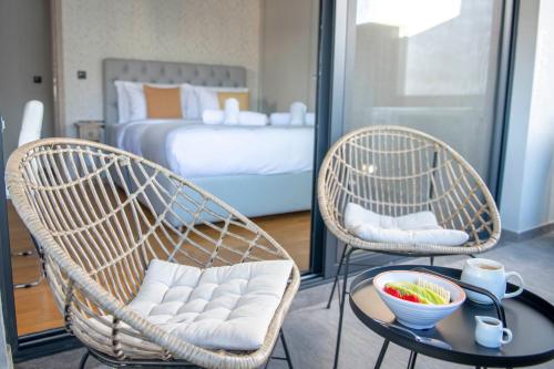 duas cadeiras e uma mesa num quarto com uma cama em Luxury Penthouse with Acropolis View and Jacuzzi em Atenas