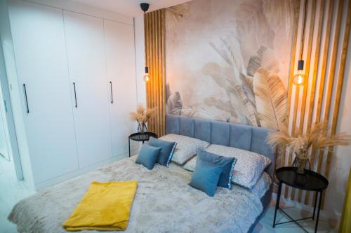 - une chambre avec un lit et des oreillers bleus dans l'établissement Nowoczesny apartament Ludova, à Biskupiec