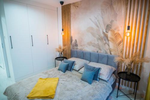 sypialnia z łóżkiem z niebieskimi poduszkami w obiekcie Nowoczesny apartament Ludova w mieście Biskupiec