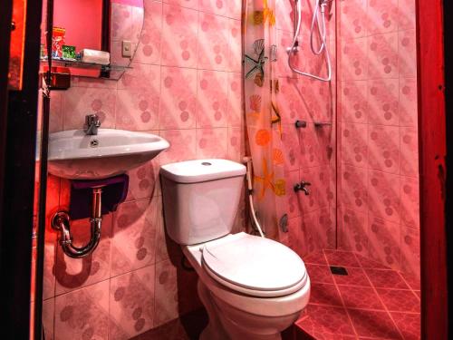 a bathroom with a toilet and a sink at OYO 622 Butterfly Totem Guesthouse in Puerto Princesa City