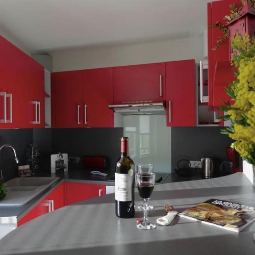 - une bouteille de vin et un verre sur un comptoir de cuisine dans l'établissement Sarlat Family 6p centre historique clim garage, à Sarlat-la-Canéda