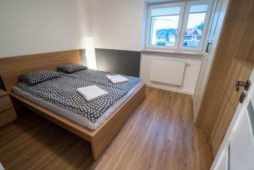 a bedroom with a bed with two pillows and a window at Filip 358 in Szklarska Poręba