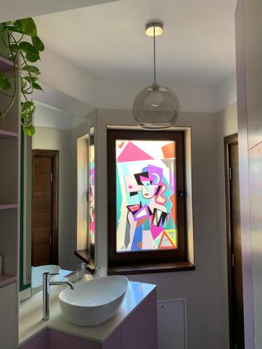a bathroom with a sink and a painting on the wall at Downtown Italian Studio in Bucharest