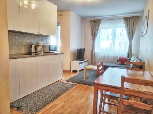 a kitchen and a living room with a table and a couch at Lovely Dream Apartment in Vilnius
