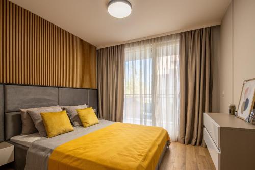 a bedroom with a bed with yellow sheets and a window at Emilia Romana Park in Sunny Beach