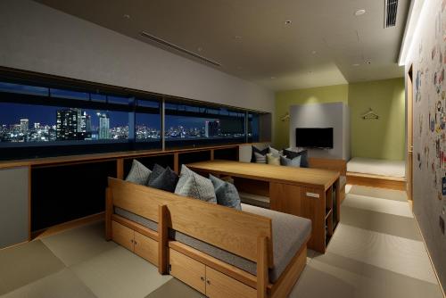 a living room with a view of a city skyline at OMO7 Osaka by Hoshino Resorts in Osaka