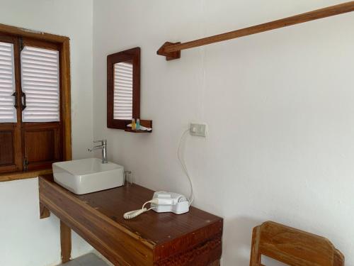 a bathroom with a sink and a mirror on a wooden table at Nongkhaiw river view in Nongkhiaw