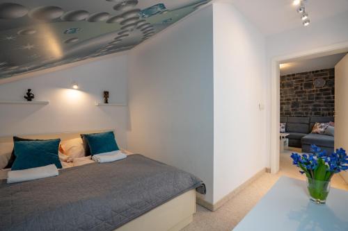 una camera da letto con un letto con cuscini blu e un divano di Apartament Nad Potokiem 41 a Szklarska Poręba