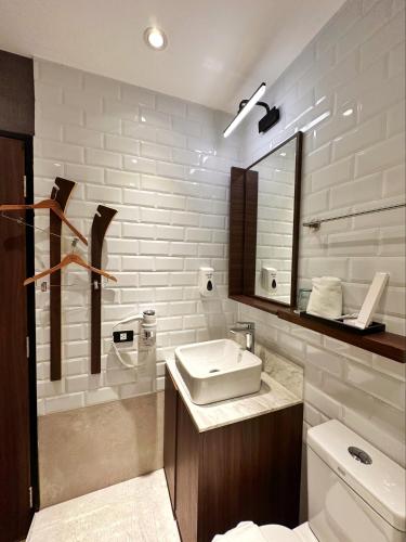 a bathroom with a sink and a toilet and a mirror at Aerotel Cebu in Mactan
