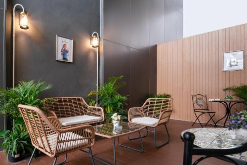a group of chairs and tables in a room with plants at Aspira Gems Center Silom in Bangkok