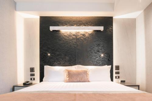 a bedroom with a large bed with a black wall at Aspira Gems Center Silom in Bangkok