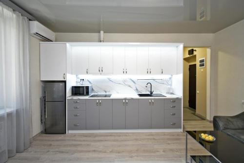 a kitchen with white cabinets and a sink at Красивая квартира на Комитас 55 in Yerevan
