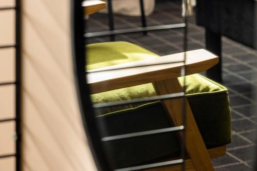 a stool with a green seat in a room at Best Western Plus Hotel Cargo in Dunkerque