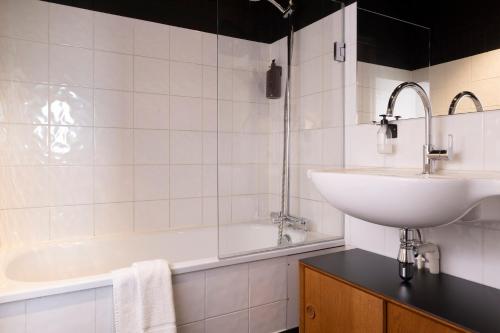 a white bathroom with a sink and a tub at Best Western Plus Hotel Cargo in Dunkerque