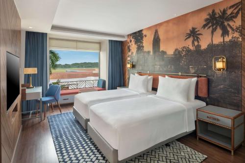 um quarto de hotel com duas camas e uma varanda em Radisson Blu Hotel GRT, Chennai International Airport em Chennai